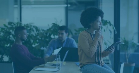 Holding tablet, African American woman gazing into distance at conference table, copy space