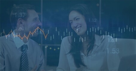 Reviewing financial charts professionals in formal wear in office at night, with financial data