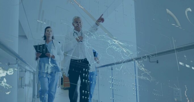 Walking doctor carrying tablet with team down hospital corridor, viewing holographic map overlay