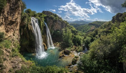 Panoramic view of a double waterfall cascading into a serene pool