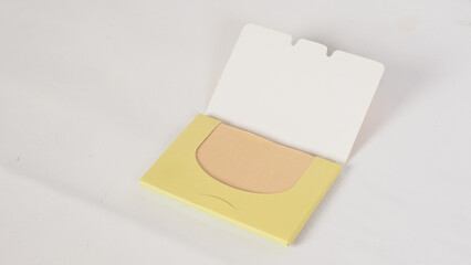 Blotting papers in a yellow case on a white background