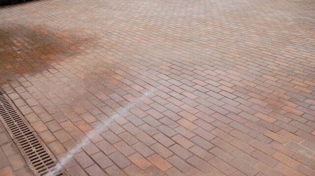 Water jet cleaning brick pavement