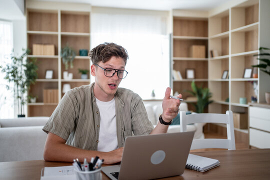 Young man working from home having video call on laptop