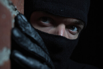 Sneaky thief at night dark alley.