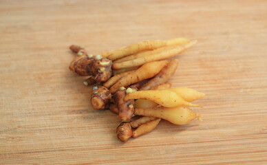Finger root or Chinese ginger on bamboo wooden background, preparation process for cooking.