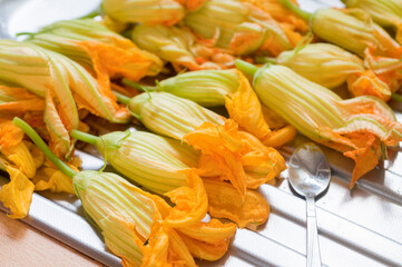 Fresh Edible Zucchini Blossoms on steel kitchen counter