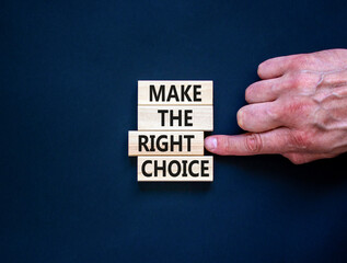 Make the right choice symbol. Concept words phrase Make the right choice on beautiful wooden blocks. Beautiful black background. Businessman's hand. Business Make the right choice concept. Copy space.