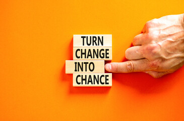 Turn change into chance symbol. Concept words phrase Turn change into chance on beautiful wooden blocks. Beautiful orange paper background. Business Turn change into chance concept. Copy space.