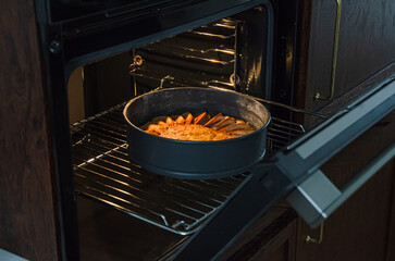 Aromatic apple pie with cinnamon baking in oven in springform pan