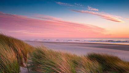 Grassy Dunes At Sunset With Pastel Pink And Orange Sky Over Sandy Beach