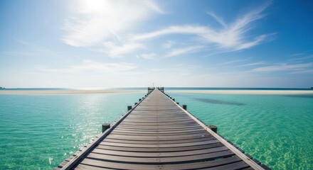 Obraz premium Wooden pier extending into turquoise water, bright sky