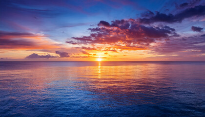 vibrant sunset over calm ocean water reflecting colorful clouds at dusk