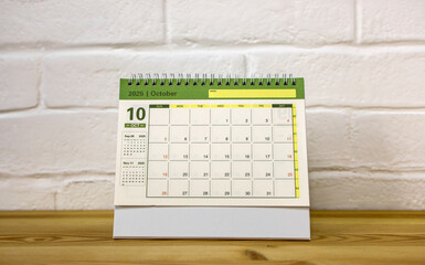 The desktop calendar for October 2025 is on the desk, where there is a place to copy.