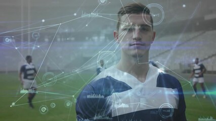 Rugby player standing center field activating data overlay showing metrics with teammates warming - Powered by Adobe