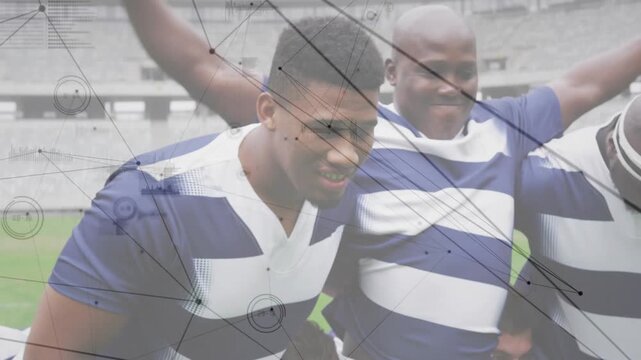 Six rugby players in striped jerseys linking arms on grass, preparing scrum formation at stadium