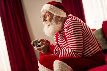 Santa Claus enjoying a cheerful gaming session indoors, bringing holiday joy and spirit to...