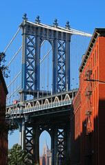 Fototapeta premium view of the Manhattan Bridge from DUMBO with the Empire State Building framed by red brick buildings