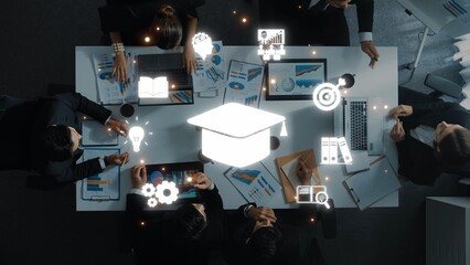 A high-angle view of a business meeting showcasing education symbols and data charts, emphasizing collaboration, learning, and innovation in a modern office setting. Raster
