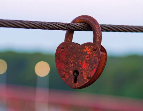 Rusty heart-shaped padlock hanging on a wire