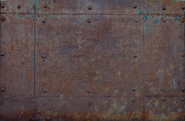Textured close-up of an old, rusty metal surface, featuring corroded steel sheets with visible...