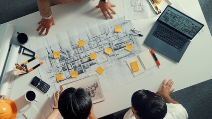 Top down aerial view of smart architect engineer team pointing and discussing about building...