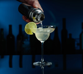 Cocktail Margarita on a black table in a bar.