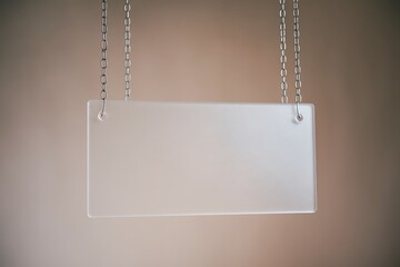 A Clear Acrylic Rectangular Hanging Sign Suspended by Two Silver Chains, Perfect for Displaying Important Information or Branding.
