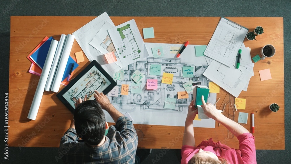 Poster top view of engineer working together to design building construction while standing at meeting tabl