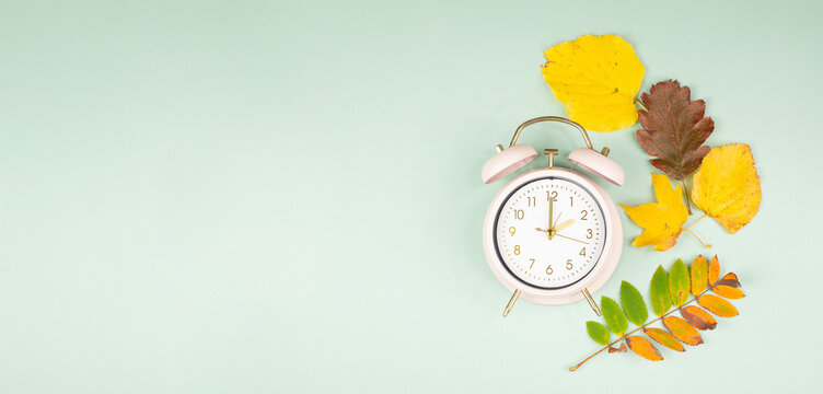 Winter time changeover, end of daylight saving time in autumn, alarm clock fall back switch, colorful foliage, change season
