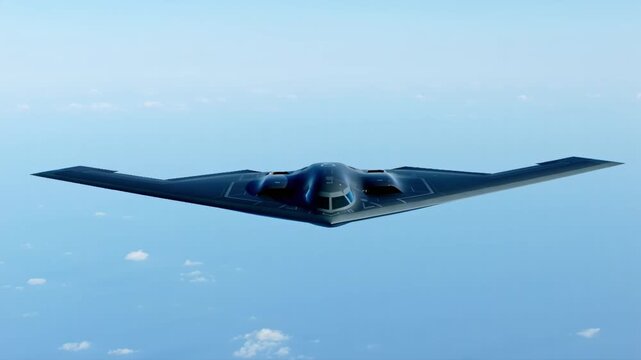 Front view of a b2 spirit stealth bomber flying high above the clouds in a clear blue sky