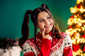 Christmas cheer with a joyful young woman, festive sweater, and glittering holiday decorations in a...