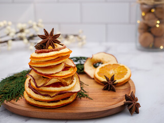 Festive Holiday tree of dehydrated dried orange and apple slices with star anise. Fall, Christmas,...