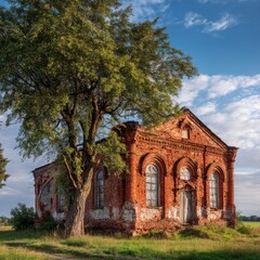 Obraz premium Old brick church under a large tree