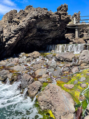 The natural volcanic rock pools of Porto Moniz in Madeira, where ocean water cascades over rugged lava formations.