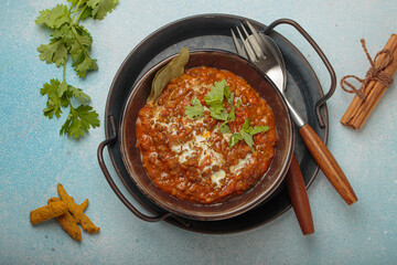 Steaming bowl of Dal makhani, a traditional indian lentil dish, garnished with fresh coriander and...