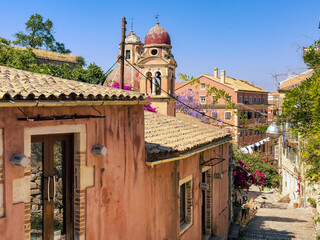 Corfu island old town. Monastery of Panagia Tenedos on a cobblestone alley. Church bell Tower, Greece. .