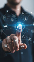 Businessman touching a digital network of interconnected icons representing business processes and people