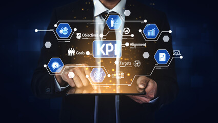 A business professional interacts with a digital tablet showcasing key performance indicators and metrics, emphasizing strategic alignment and goal achievement. Tessel
