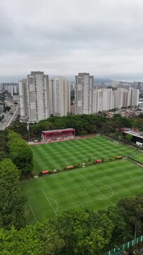 Vis&atilde;o a&eacute;rea de campo de futebol profissional mostra gramado bem cuidado, arquibancadas e marca&ccedil;&otilde;es esportivas, destacando infraestrutura moderna voltada para competi&ccedil;&otilde;es e eventos esportivos