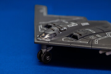 Top view of a B-2 Spirit stealth bomber scale model displayed on a blue surface. The iconic flying wing design represents modern aviation, stealth technology, and military air power