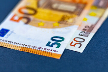 Close-up photo of two 50 euro banknotes, one from the old 2002 series and the other on top is from...