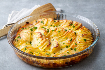 Potato gratin - graten (baked potatoes with cream and cheese) with rosemary and forks (Turkish...