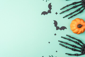 Halloween theme with skeleton hands, bats, stars, and pumpkin on light green background