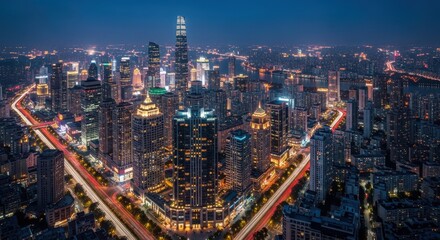 Fototapeta premium Nighttime Aerial View of Modern Cityscape with Illuminated Skyscrapers and Traffic Trails