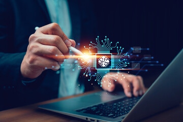 Businessman using digital pen with holographic microchip and circuit board above laptop. Concept of...