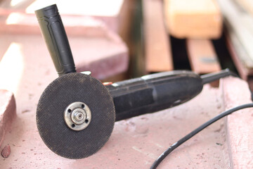 Angle grinders, power tools for construction and repair work. Tool for cutting and grinding hard materials. Old angle grinder with cord. Repair work in the country. Grinder with a metal disc
