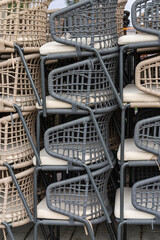 Stacked Rattan Chairs from a Cafe or Restaurant. Concept of the end of the season or business hours