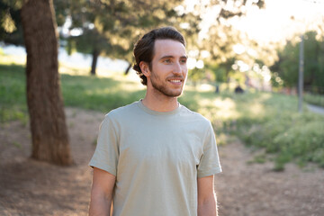 Young man smiling and enjoying nature in a public park