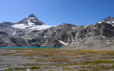 The peak Granta Parey and the Goletta glacier in the Graian Alps in Italy. Glacial lake Goletta of turquoise color, fed by the melting waters of the glacier. Hiking trail from refuge Benevolo.