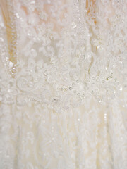 Elegant lace wedding dress embellished with intricate beadwork displayed in a soft and romantic setting